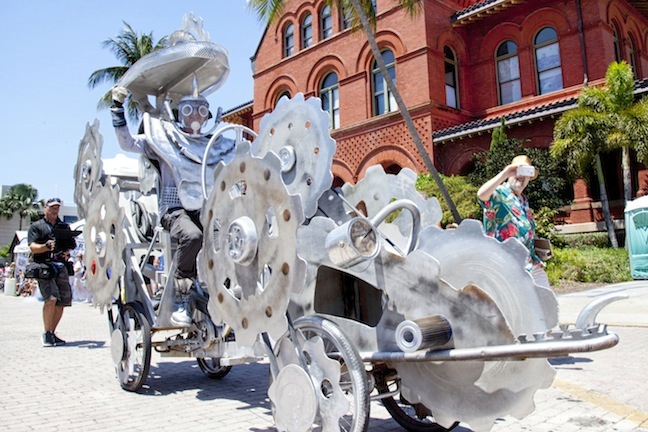 Steve King rolls past the Custom House Museum with his pedal-and-belt-driven creation “Time Chaser.”  Following in pioneering folk artist Stanley Papio’s footsteps, King used recycled materials combining wood, metal, bike parts, and “bits and bobs” to make his award-winning gear-and-cogs-inspired design, one of more than thirty kinetic creations that participated in the rolling cavalcade held in honor of the late welder-turned artist. The zany spectacle of creative whimsy and kinetic savvy was supported in part by a prestigious grant awarded to the Society by the Knight Arts Challenge People's Choice Award, a competition that rewards the best and most innovative ideas for the arts. A permanent exhibit celebrating Papio’s work is now open at Fort East Martello Museum in Key West, and preparations are already underway for next year’s kinetic festivities.  Visit KWAHS.ORG for more information.